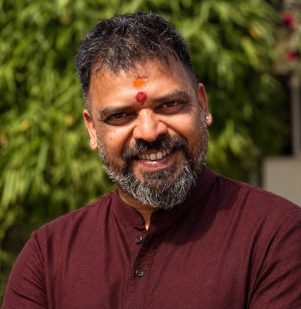 Kishore Krishna Atmakuri smiling in a maroon kurta